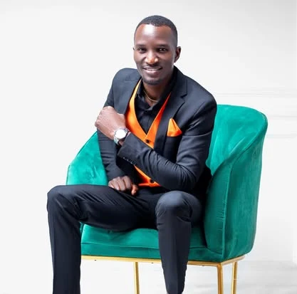 Maxwell Changilwa seated in a green armchair