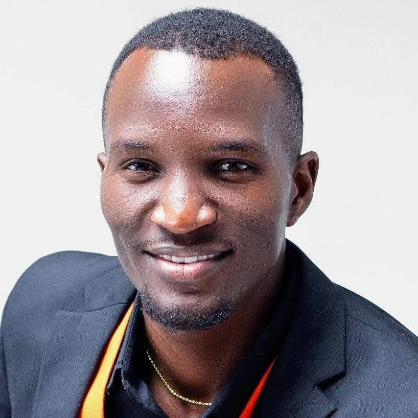 Maxwell Changilwa smiling, wearing a dark blazer